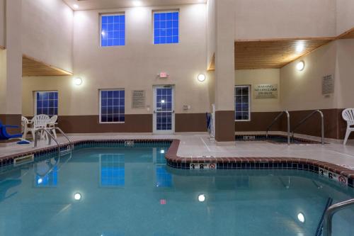 a large swimming pool with blue water in a building at GrandStay Hotel & Suites Ames in Ames