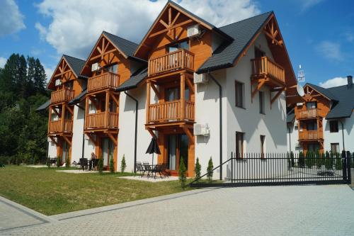 un edificio con balcones de madera en un lateral en Apartament Homole E2 Szczawnica en Szczawnica