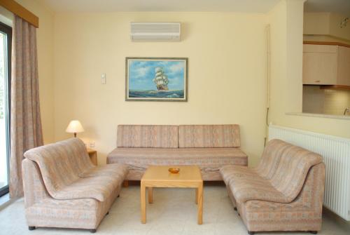 a living room with a couch and two chairs at Niki Hotel Apartments in Ialyssos
