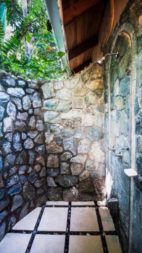 a stone wall with a shower in a room at Hotel El Pequeño Gecko Verde in Sámara