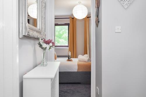 een kleine slaapkamer met een bed en een raam bij Gloucester Green Suite in Oxford