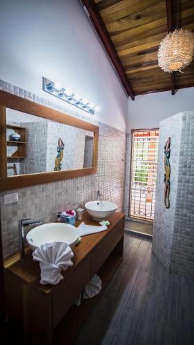 a bathroom with two sinks and a large mirror at Hotel El Pequeño Gecko Verde in Sámara