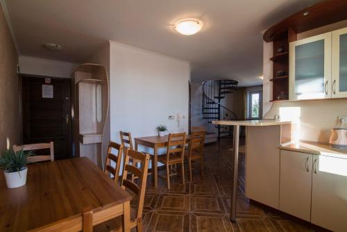 a kitchen and dining room with a table and chairs at PIONOW Rodzinne Apartamenty Urocza 10 in Krynica Morska