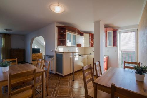 a kitchen and dining room with wooden tables and chairs at PIONOW Rodzinne Apartamenty Urocza 10 in Krynica Morska