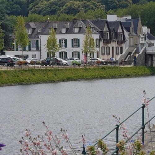 a view of a river with houses and buildings at Chambres Dhôtes Numéro 1 in Châteaulin
