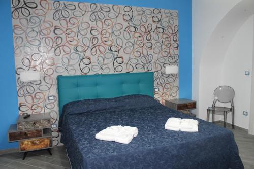 Un dormitorio con una cama azul con toallas. en casavacanzeivana, en Pizzo