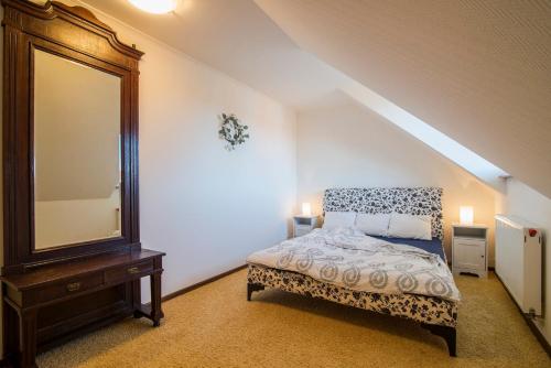 a bedroom with a bed with a mirror and a dresser at PIONOW Rodzinne Apartamenty Urocza 10 in Krynica Morska