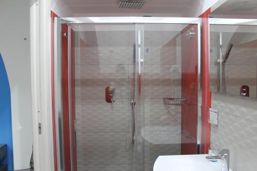 a shower with a glass door next to a sink at casavacanzeivana in Pizzo