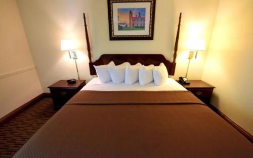 a hotel room with a large bed with two lamps at Bayside Hotel of Mackinac in Mackinaw City