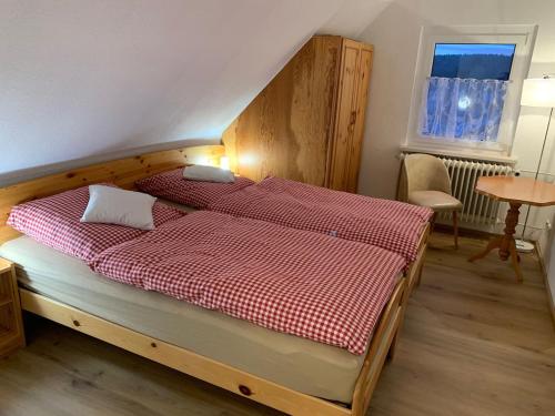 um quarto com uma cama com um cobertor xadrez vermelho em Ferienhaus Lilo em Braunlage