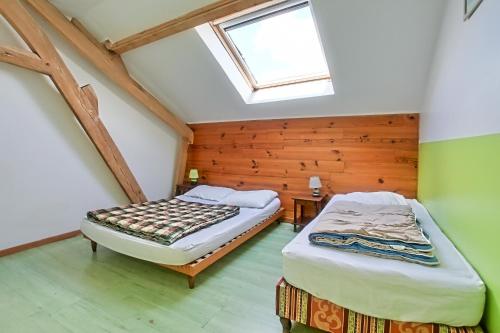 two beds in a attic bedroom with a skylight at Gîtes "LA JUMEL" à 25 min du Touquet, à la Campagne et à la Mer in Beaurainville