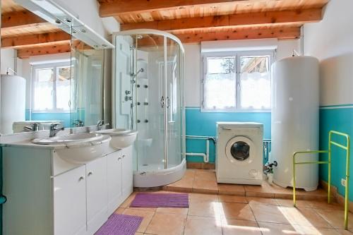 a bathroom with two sinks and a shower and a washing machine at Gîtes "LA JUMEL" à 25 min du Touquet, à la Campagne et à la Mer in Beaurainville