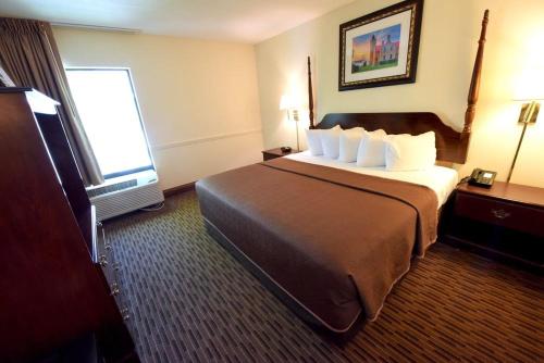 a hotel room with a large bed and a window at Bayside Hotel of Mackinac in Mackinaw City