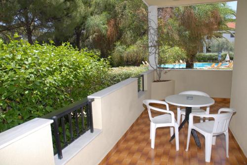 a patio with a table and chairs on a balcony at Niki Hotel Apartments in Ialyssos