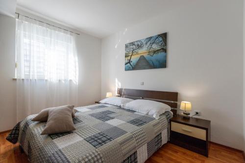 a bedroom with a bed and a table and a window at Holiday house Mary in Barban