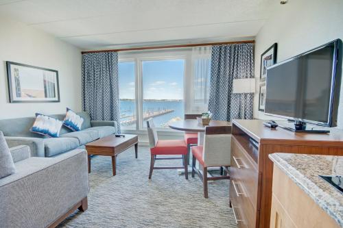 a living room with a large television and a couch at Club Wyndham Inn on the Harbor in Newport