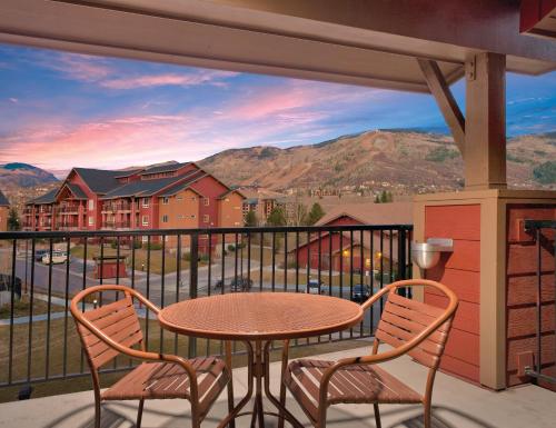 a dining room table with a balcony overlooking a city at Club Wyndham Steamboat Springs in Steamboat Springs