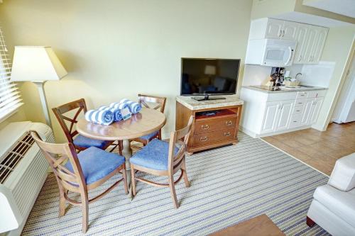 a living room with a table and chairs and a kitchen at Club Wyndham Inn on Long Wharf in Newport