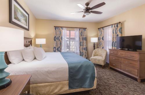 a bedroom with a bed and a flat screen tv at Club Wyndham Branson at The Meadows in Branson