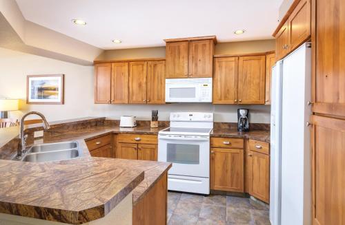 a kitchen with wooden cabinets and white appliances at WorldMark Arrow Point in Coeur d'Alene