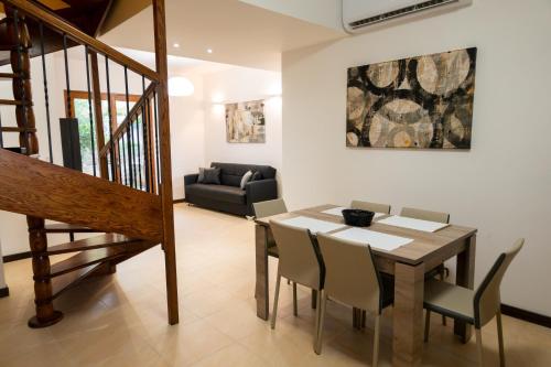 ein Esszimmer mit Tisch und Stühlen und einer Couch in der Unterkunft GetawayNpetto Private Duplex Maisonette with Jacuzzi Hot Tub in Mġarr