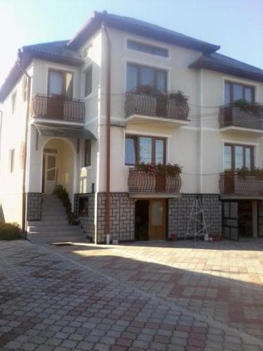 a large white building with stairs and balconies on it at Pensiunea Georgiana in Şieu
