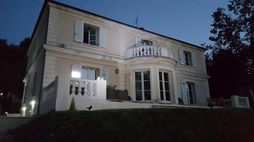 a white house with a balcony on top of it at la source de bougival in Bougival