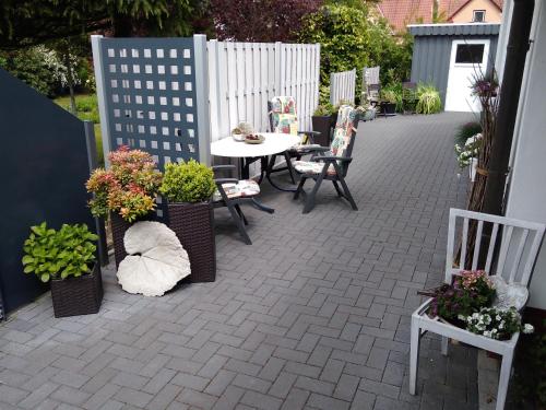 a patio with a table and chairs and plants at Tauchparadies Kreidesee in Hemmoor