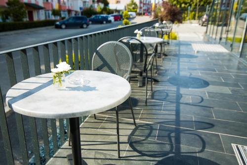 a row of tables and chairs on a sidewalk at Hotel Subcarpati in Curtea de Argeş