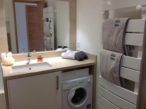 une salle de bain avec un lavabo et une machine à laver dans l'établissement Le Pêcheur, à Cavalaire-sur-Mer