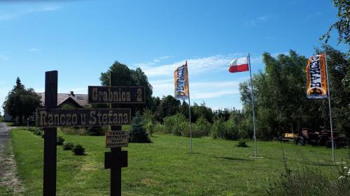 a street sign in front of a field with flags at Ranczo u Stefana in Ustronie Morskie