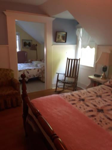 1 dormitorio con 1 cama y 1 silla en una habitación en Gables Bed & Breakfast en Stayner