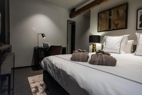 a bedroom with a large white bed with towels on it at Boutiquehotel 't Fraeyhuis - adults only in Bruges