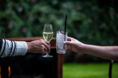 two people holding a glass of white wine at Boutiquehotel 't Fraeyhuis - adults only in Bruges