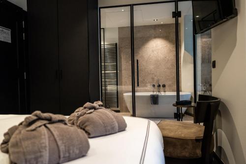 a bedroom with a bed and a tub and a sink at Boutiquehotel 't Fraeyhuis - adults only in Bruges