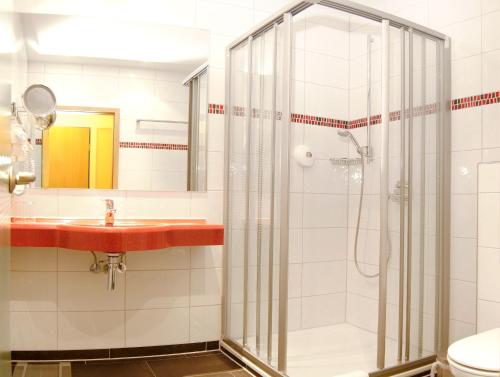 uma casa de banho com um chuveiro e um lavatório. em Hotel Bügener em Gronau