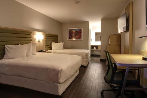 una camera d'albergo con due letti e un tavolo di GreenTree Inn Flagstaff a Flagstaff