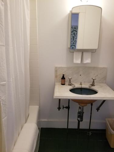 a bathroom with a sink and a bath tub at Harbourside Inn in Northeast Harbor