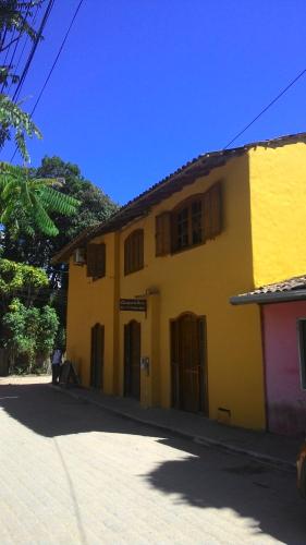 a yellow building with a person standing in front of it at Casas da Bete in Trancoso