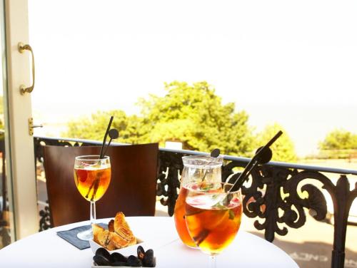 two glasses of wine sitting on a table at Crown Spa Hotel Scarborough by Compass Hospitality in Scarborough