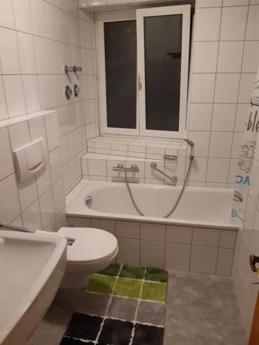 une salle de bain avec une baignoire, des toilettes et un lavabo dans l'établissement Riverside, à Füssen