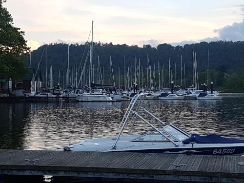 a boat docked at a dock with boats in the water at Bowness Guest House in Bowness-on-Windermere