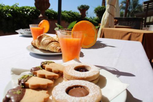 - une table avec un plateau de viennoiseries et de jus d'orange dans l'établissement IL Ciliegio Dell 'Etna, à Giarre