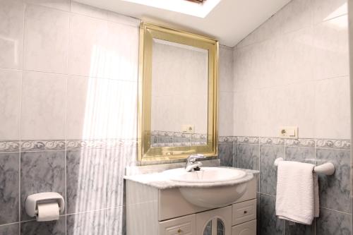 un baño con lavabo y espejo en La casita de Triana, en Cambados