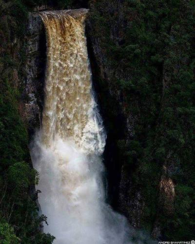 a large waterfall in the middle of a forest at Cabañas Guacari San Agustín huila in San Agustín