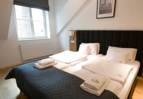 a bedroom with a bed with towels on it at Aparthotel BC 29 Residence in Kraków