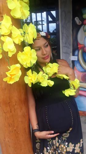 a woman wearing a dress with yellow flowers on it at Cabañas Guacari San Agustín huila in San Agustín