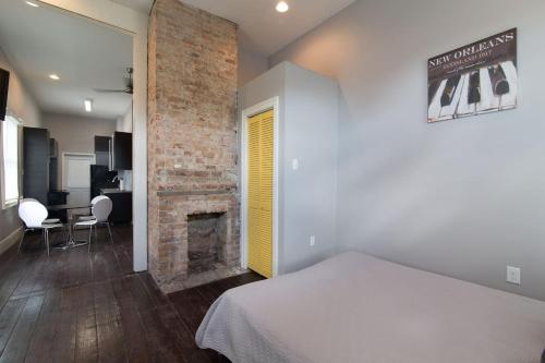 a bedroom with a bed and a brick fireplace at Modern Condo 2 Blocks From Quarters in New Orleans