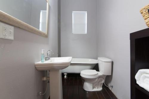 a white bathroom with a sink and a toilet at Modern Condo 2 Blocks From Quarters in New Orleans