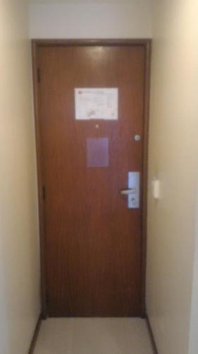 a wooden door in a room with a sign on it at Apart Hotel Quartier Latin in Vitória